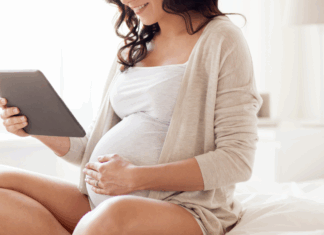 A pregnant woman looking at a calendar.
