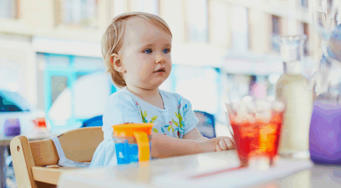 A kid sitting at a table in a restaurant.
