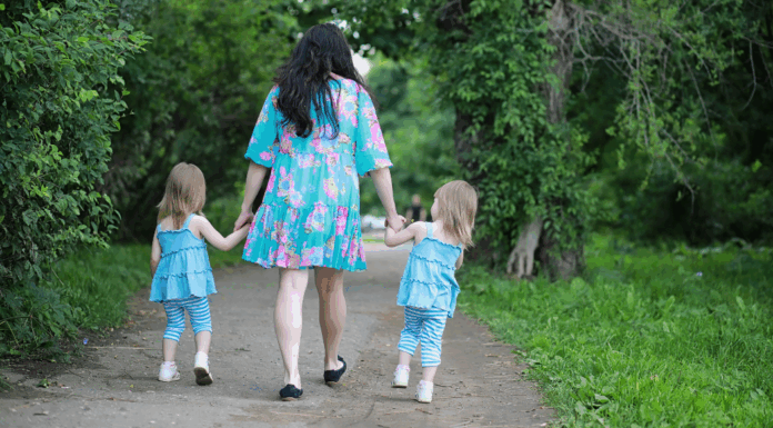 A mom walking with twins.