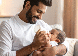 A dad feeding a baby a bottle.