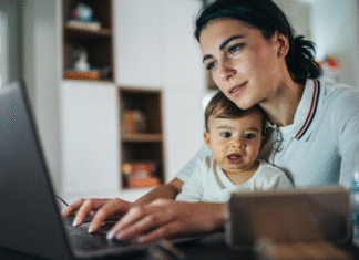 4 Practical Tips for Returning to Work After Maternity Leave A woman working while holding her baby.