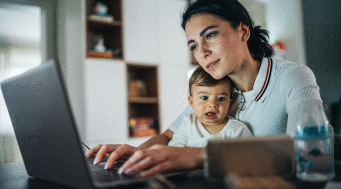 A woman working while holding her baby.