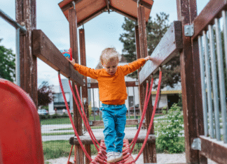 A boy on a wooden playground set.