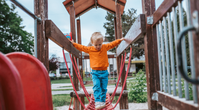 A boy on a wooden playground set.
