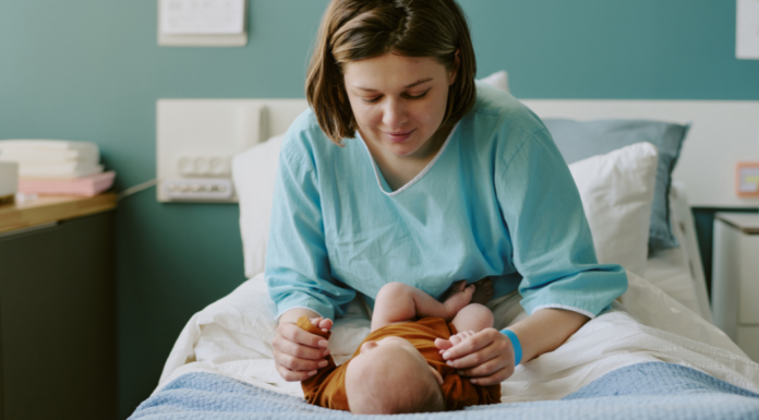 A woman postpartum in the hospital with her baby.