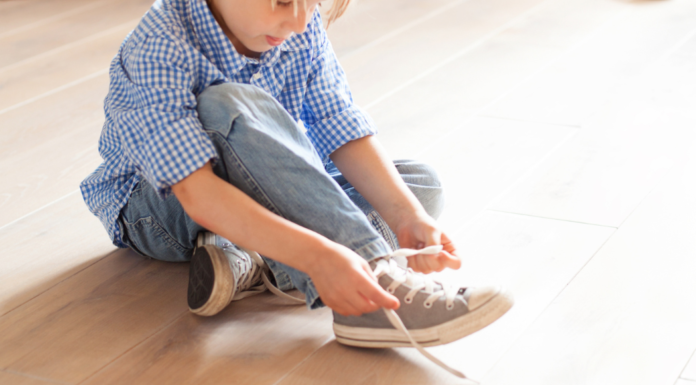 A boy tying his shoe.