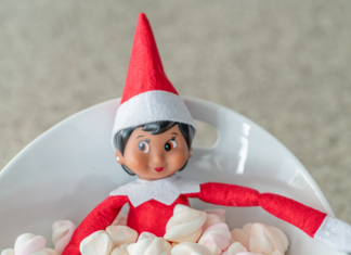 An elf on a shelf in a bowl of marshmallows.