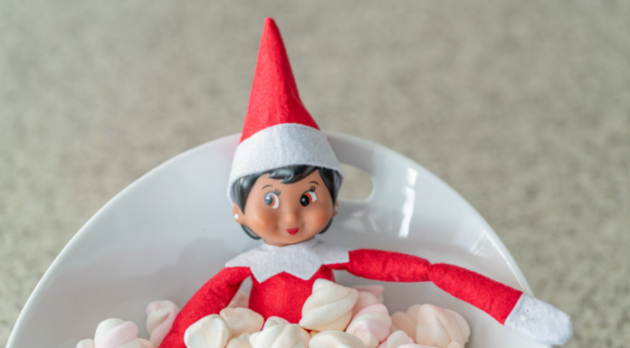 An elf on a shelf in a bowl of marshmallows.