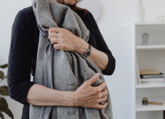 A woman holding a blanket against her body.