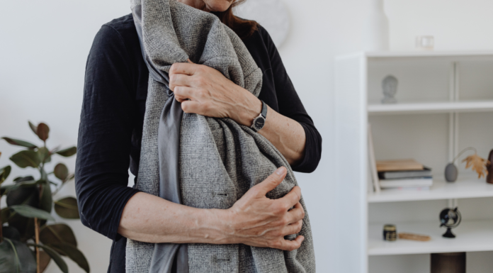 A woman holding a blanket against her body.
