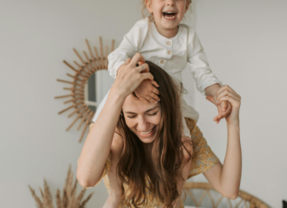 5 Signs You Might Be a Mommy Martyr A mom carrying her child on her shoulders.