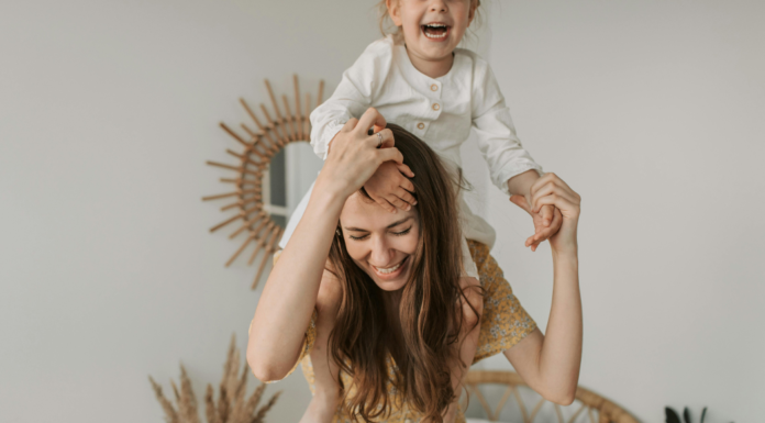 A mom carrying her child on her shoulders.