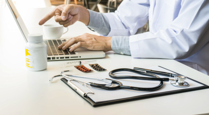 A doctor looking up something on his computer.
