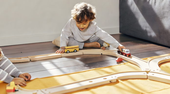 A boy playing with toy train tracks.