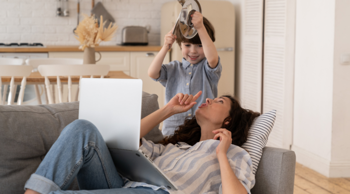 A boy banging above his mom's head while she tries to work on her computer.