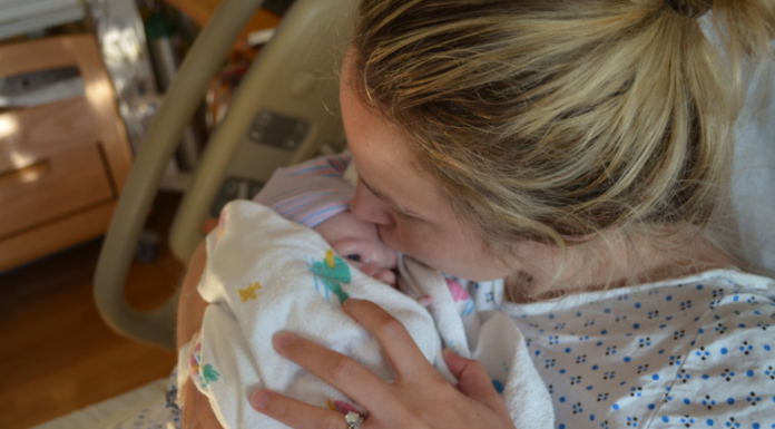 Maria- F holding her firstborn baby.