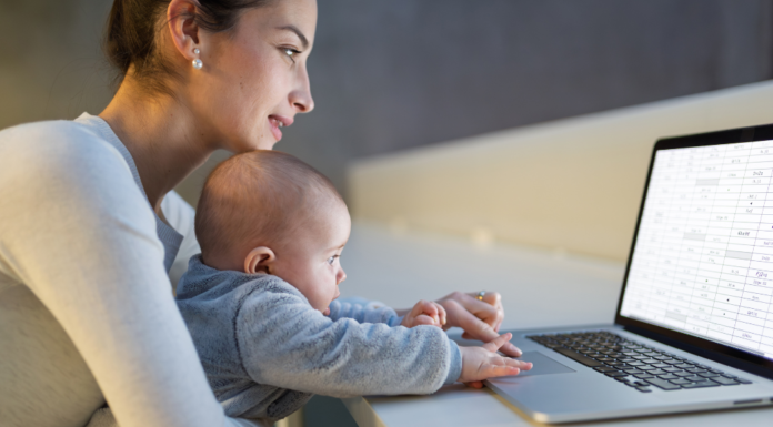 A mom holding her baby while she looks up information online.