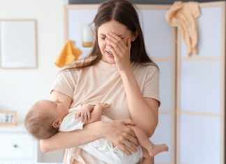 A postpartum mom holding her baby.