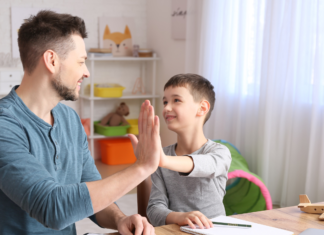 A father and son touching hands.