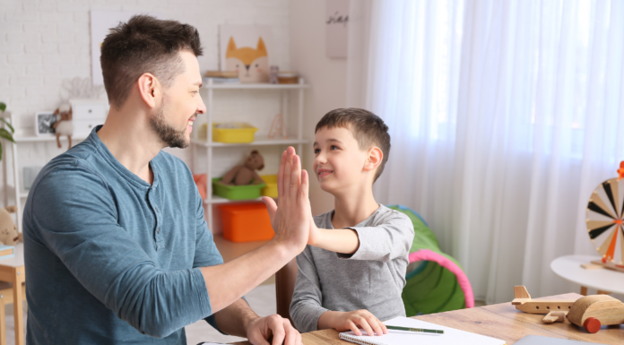 A father and son touching hands.