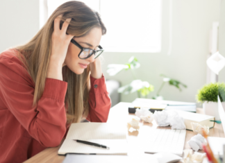 Stuck in a Rut: The Uninspired Parent A woman stressed at her desk looking at papers.