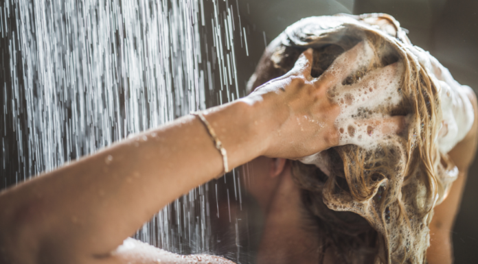 Washing your hair with shampoo.