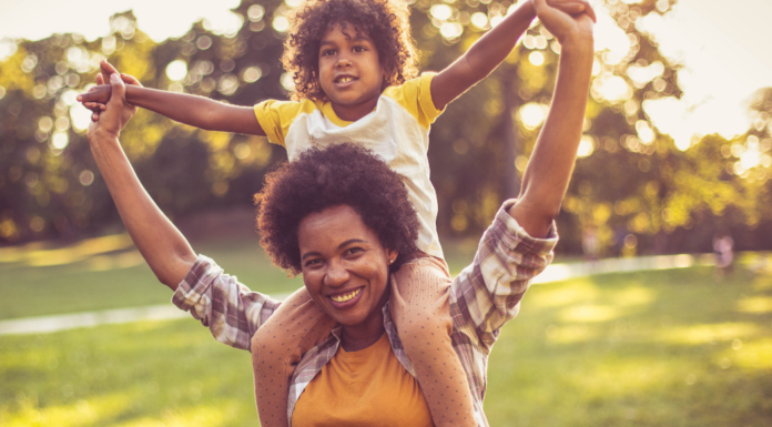A mom with her son on her shoulders.