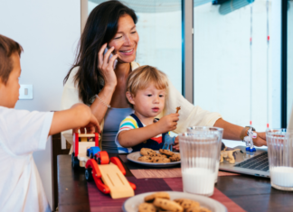 A mom with her kids trying to work at the kitchen table.