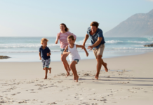 A family running on the beach.
