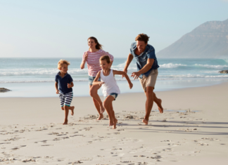 A family running on the beach.