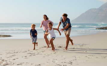 A family running on the beach.