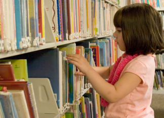A girl looking at books at the library.
