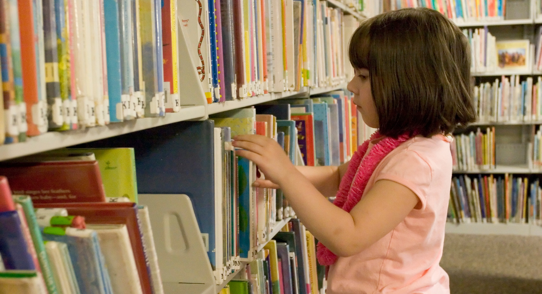 A girl looking at books at the library.