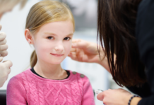 A girl getting her ears pierced.