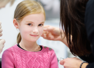 A girl getting her ears pierced.