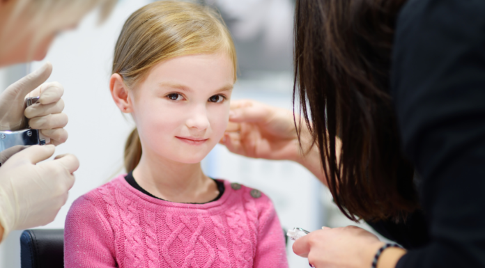 A girl getting her ears pierced.