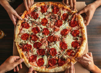 People reaching for pizza.
