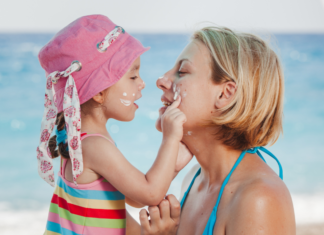 A daughter putting sunscreen on her mom's face.
