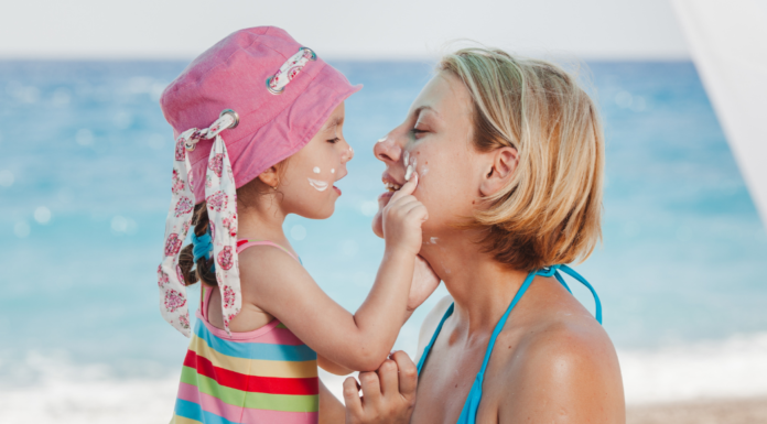 A daughter putting sunscreen on her mom's face.