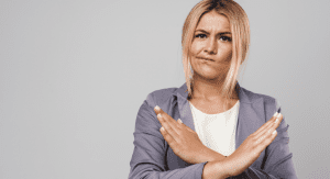 Woman smirking and making an x with her arms.