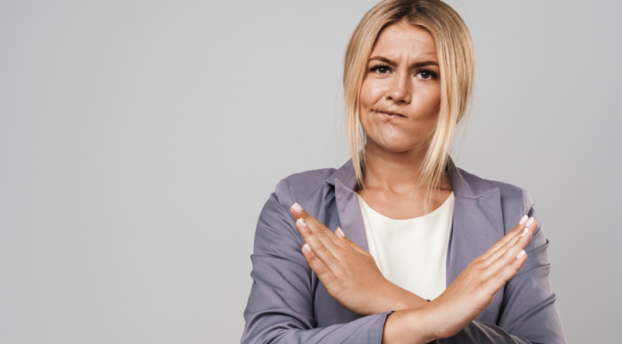 Woman smirking and making an x with her arms.