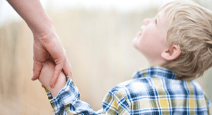 Holding hands with a little boy looking up.