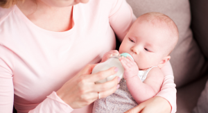 A woman bottle-feeding a baby.
