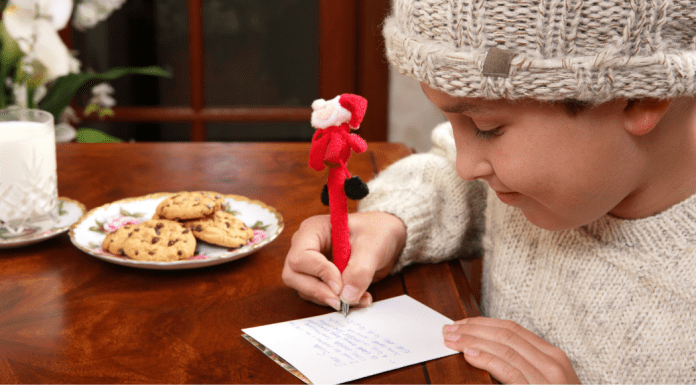 A little boy writing his holiday wish list.