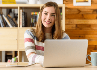 Woman sitting at a computer smiling.
