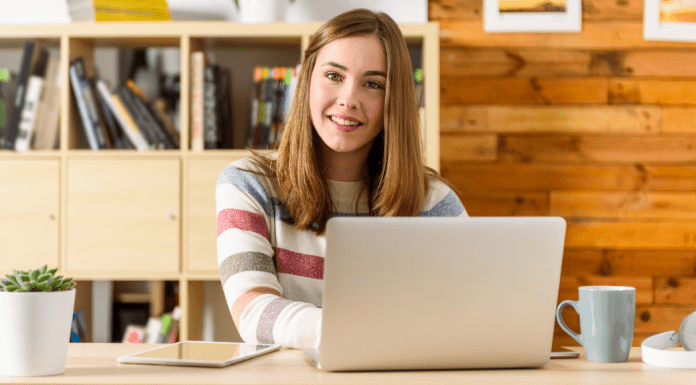 Woman sitting at a computer smiling.