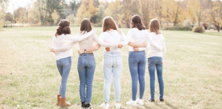 Girls standing with their arms around each other.