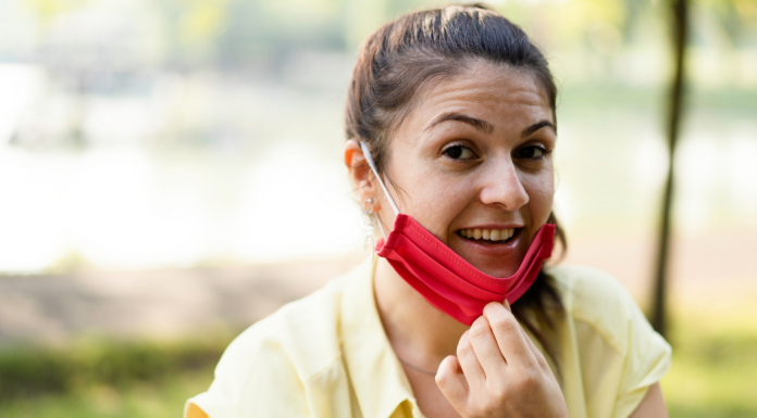 A woman pulling down her mask.