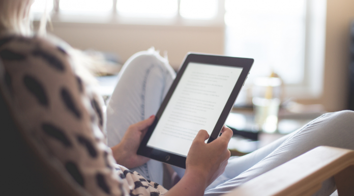 A woman reading on a Kindle.
