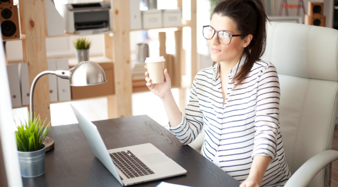 A pregnant working mom sitting at her desk.